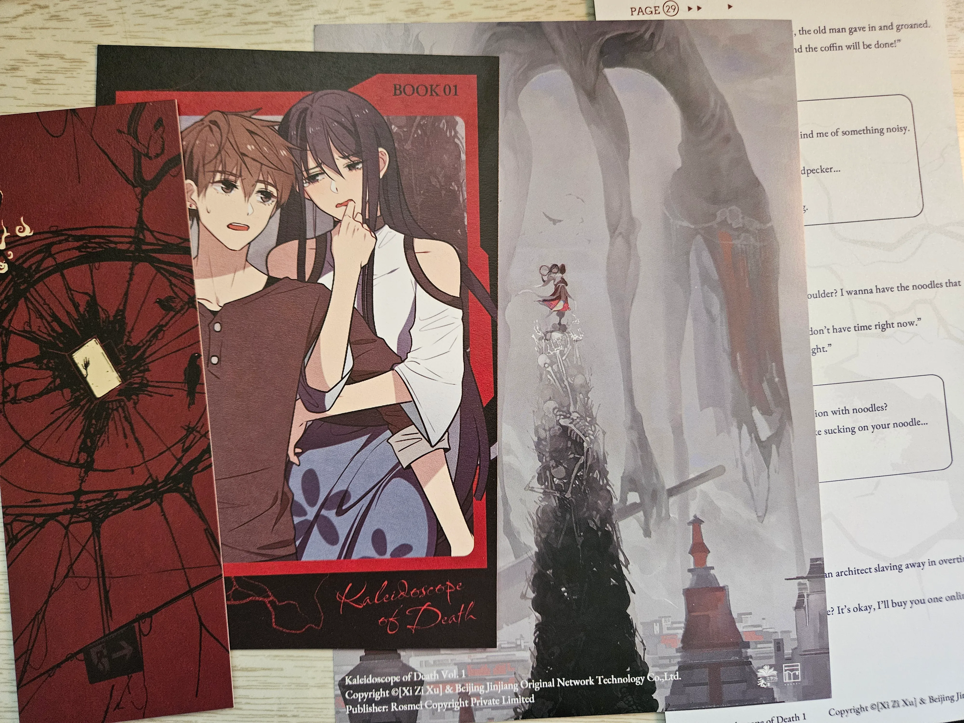a bookmark, postcard, cover art print, and pamphlet that came with kaleidoscope of death volume 1